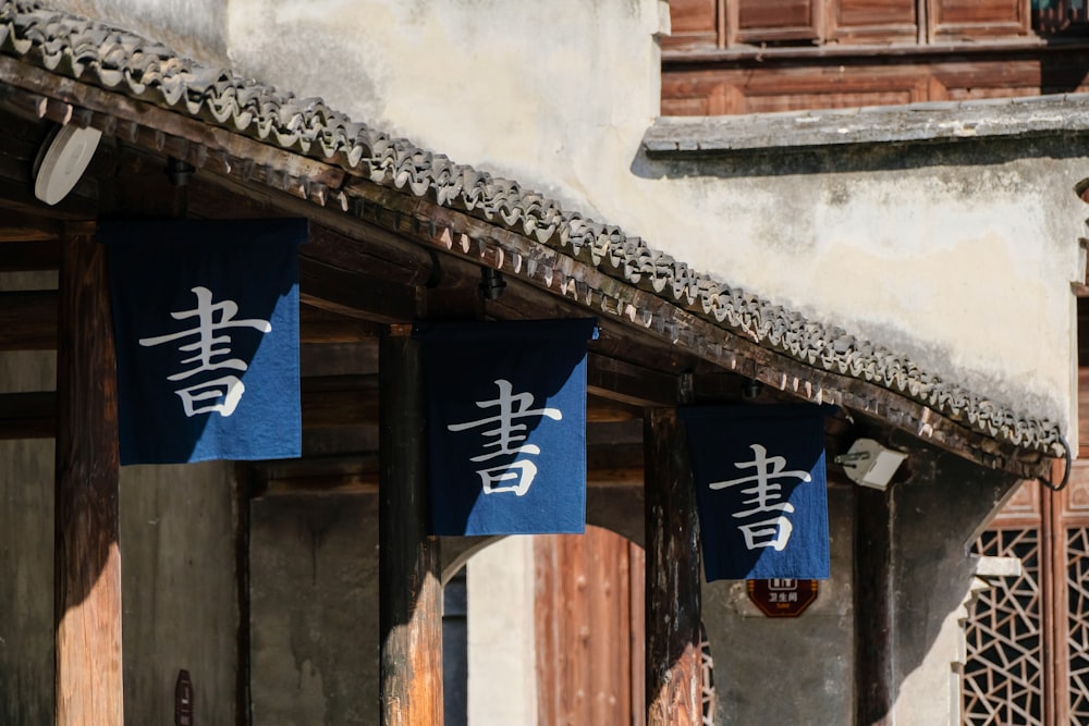 a row of blue banners hanging from the side of a building