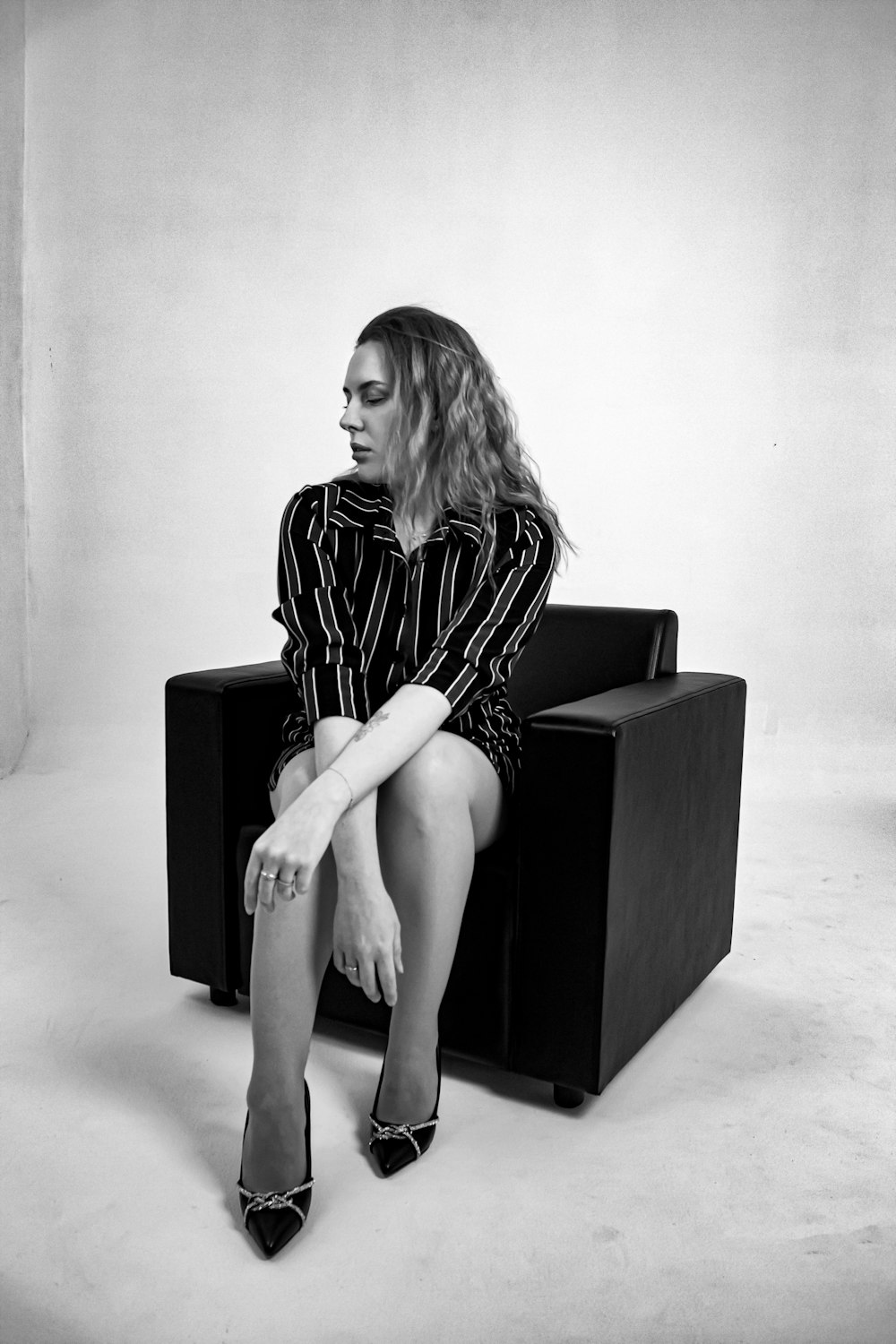 a black and white photo of a woman sitting on a chair
