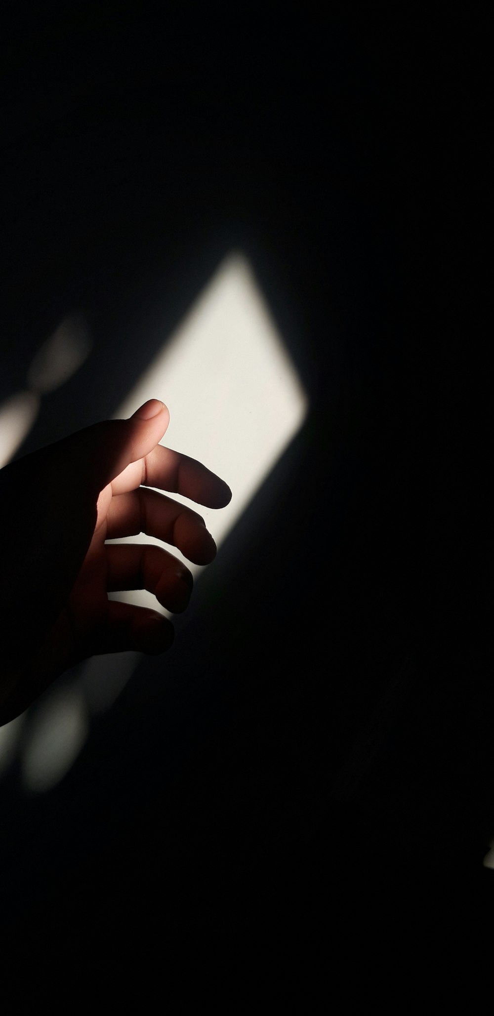 a person's hand reaching for something in the dark