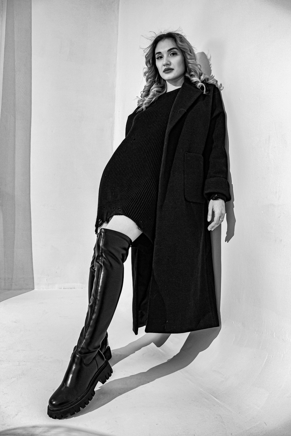 a black and white photo of a woman in boots