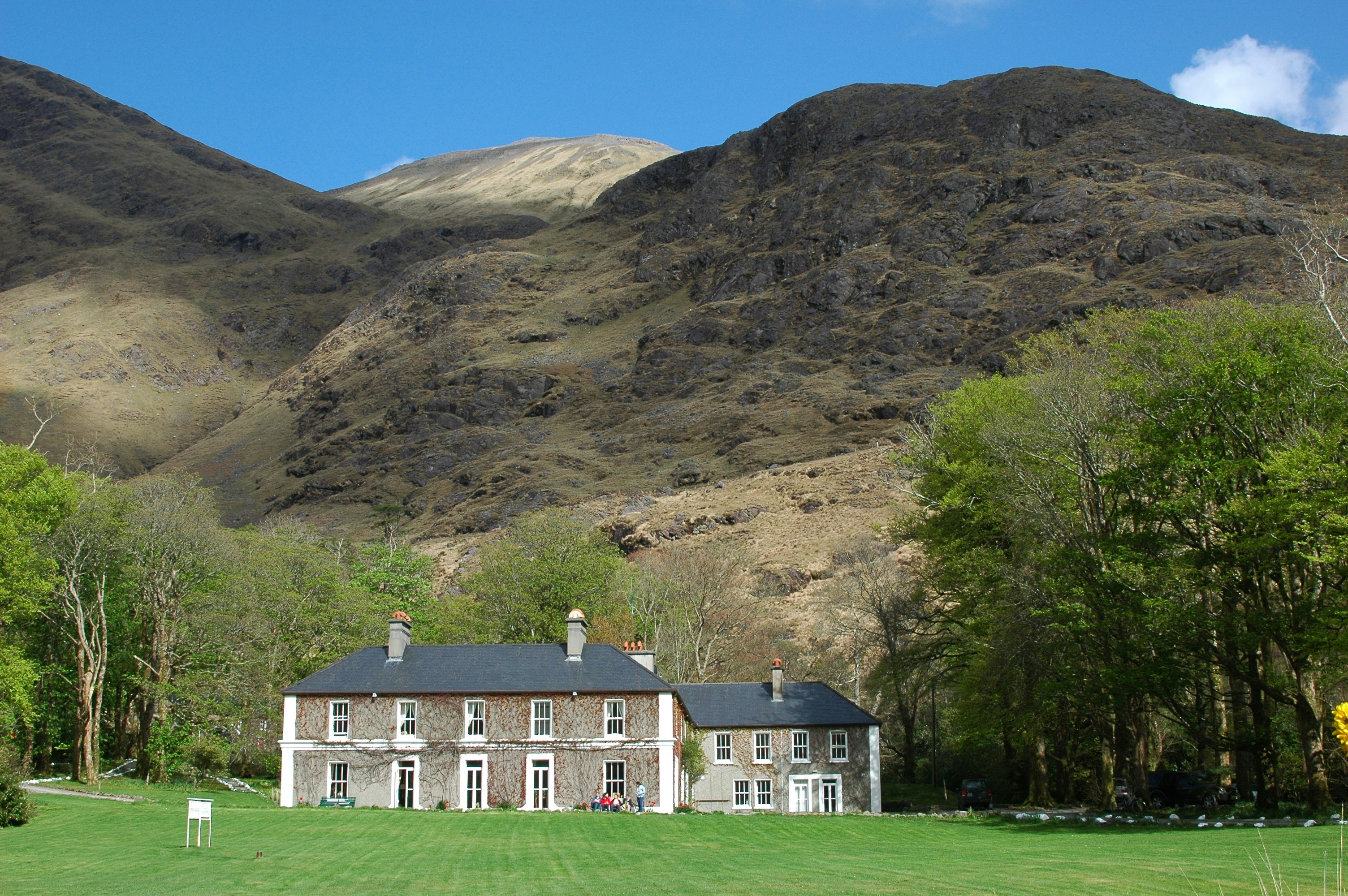 a large house in the middle of a lush green field