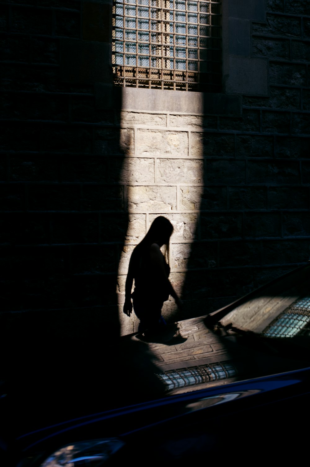 a person standing in the shadows of a building