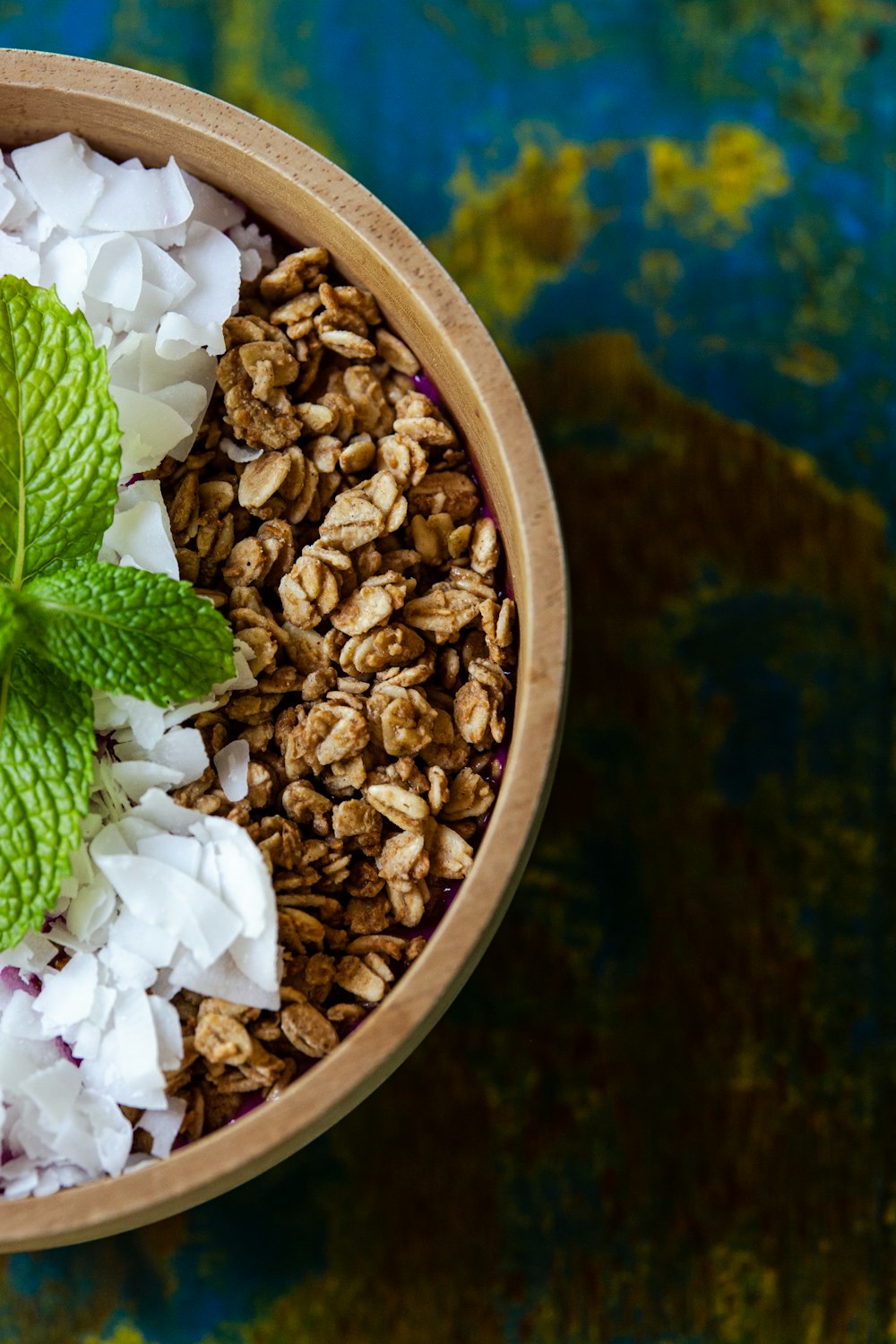 a bowl of granola with a mint leaf on top