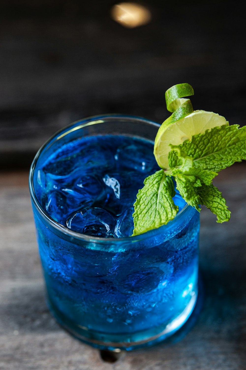 a blue drink with a lime garnish on the rim