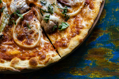 Close-up of a wood-fired artisanal pizza with bubbling cheese and fresh basil.