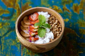 A rustic bowl filled with fresh fruits and natural ingredients used for making ice cream.