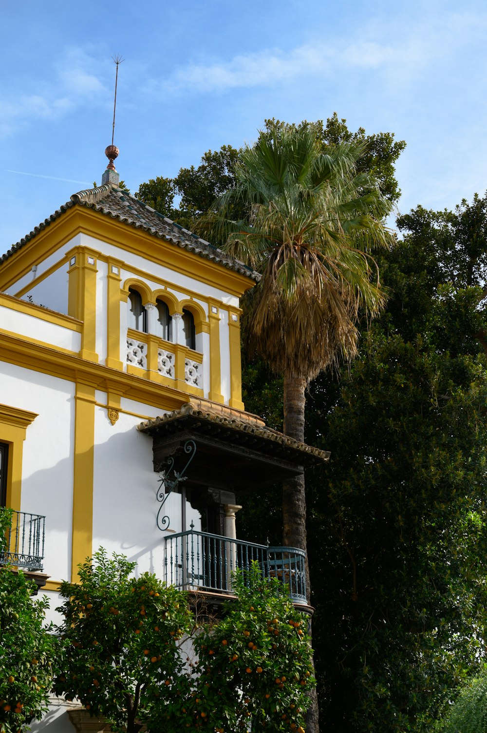 a yellow and white house with a palm tree in front of it