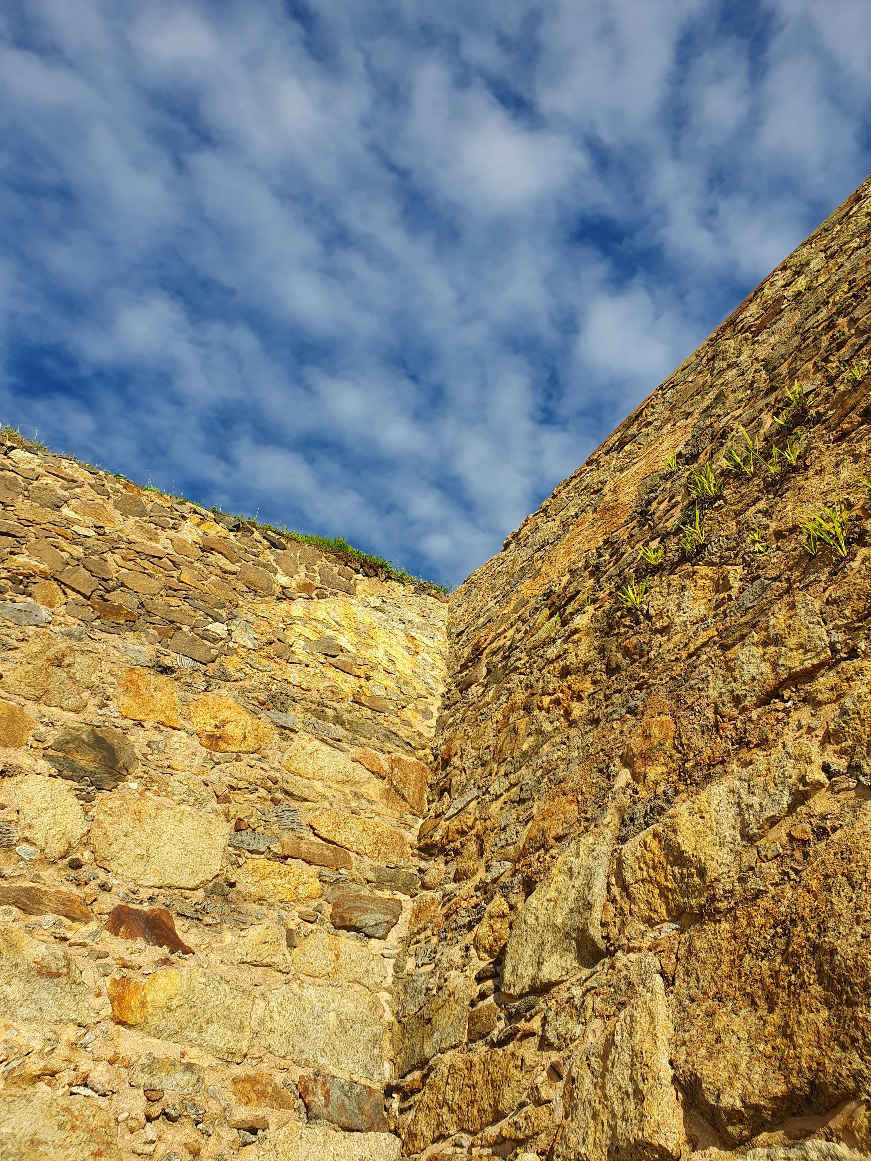 a stone wall with a blue sky in the background