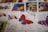 A collection of colorful postage stamps featuring butterfly illustrations. The focus is on a stamp with a vibrant butterfly in red, blue, and brown hues. Other stamps with different butterfly designs and colors are visible in the background, creating an artistic and eclectic display.