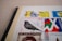 A collection of colorful postage stamps is displayed, featuring various designs including a bird, abstract shapes, and a portrait. The stamps are affixed to an album page, with some text visible in Cyrillic script.