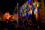 A nighttime shot of a building facade illuminated by colorful LED lights.