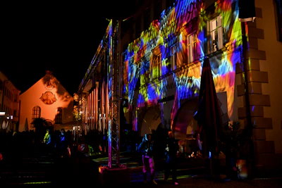 A nighttime shot of a building facade illuminated by colorful LED lights.
