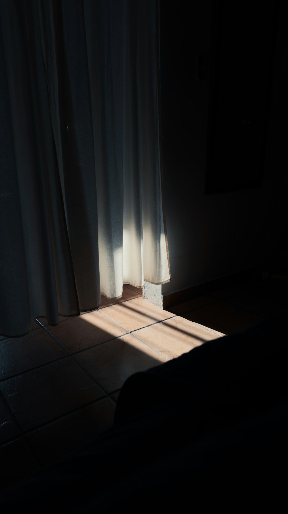 the sun is shining through the curtains in the room