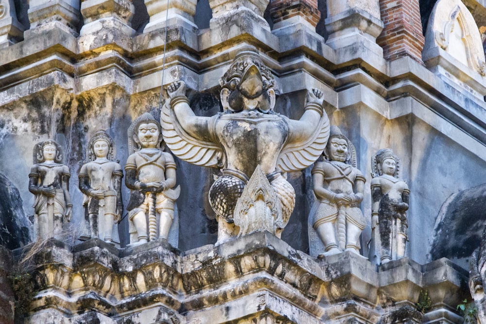 a close up of a building with statues on it