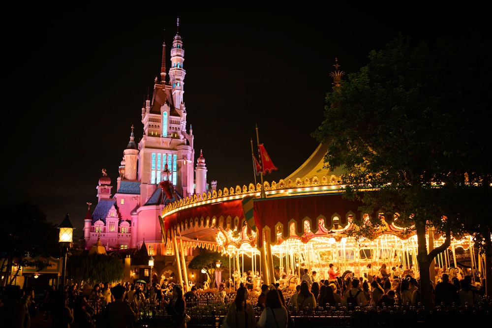 a merry go round at night with people walking around