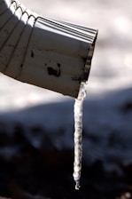 Close-up of a leak-sealing system being applied inside a downspout.