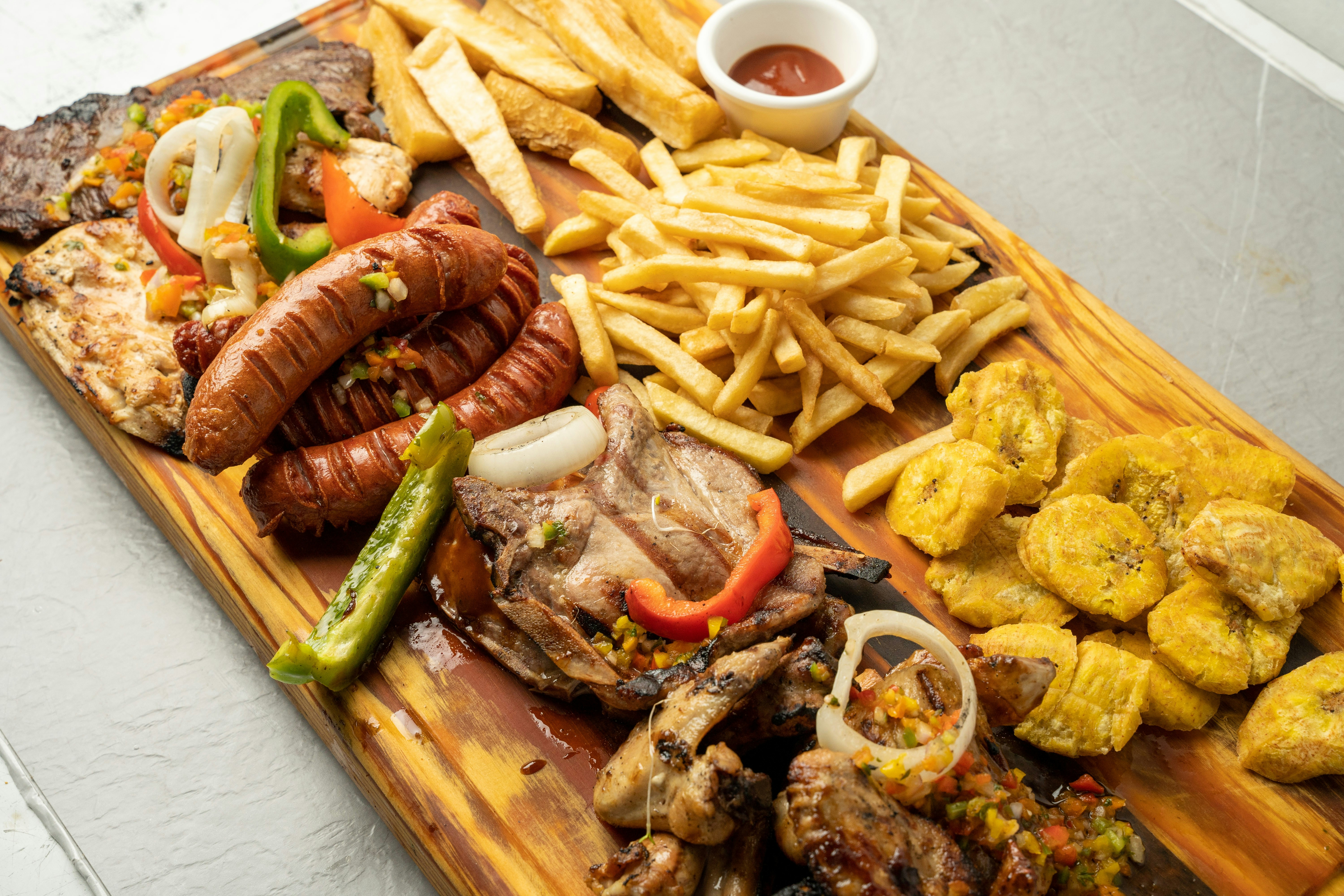 a wooden cutting board topped with lots of food, 