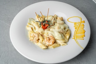 a white plate topped with pasta and shrimp