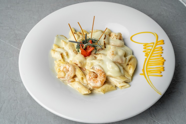 a white plate topped with pasta and shrimp