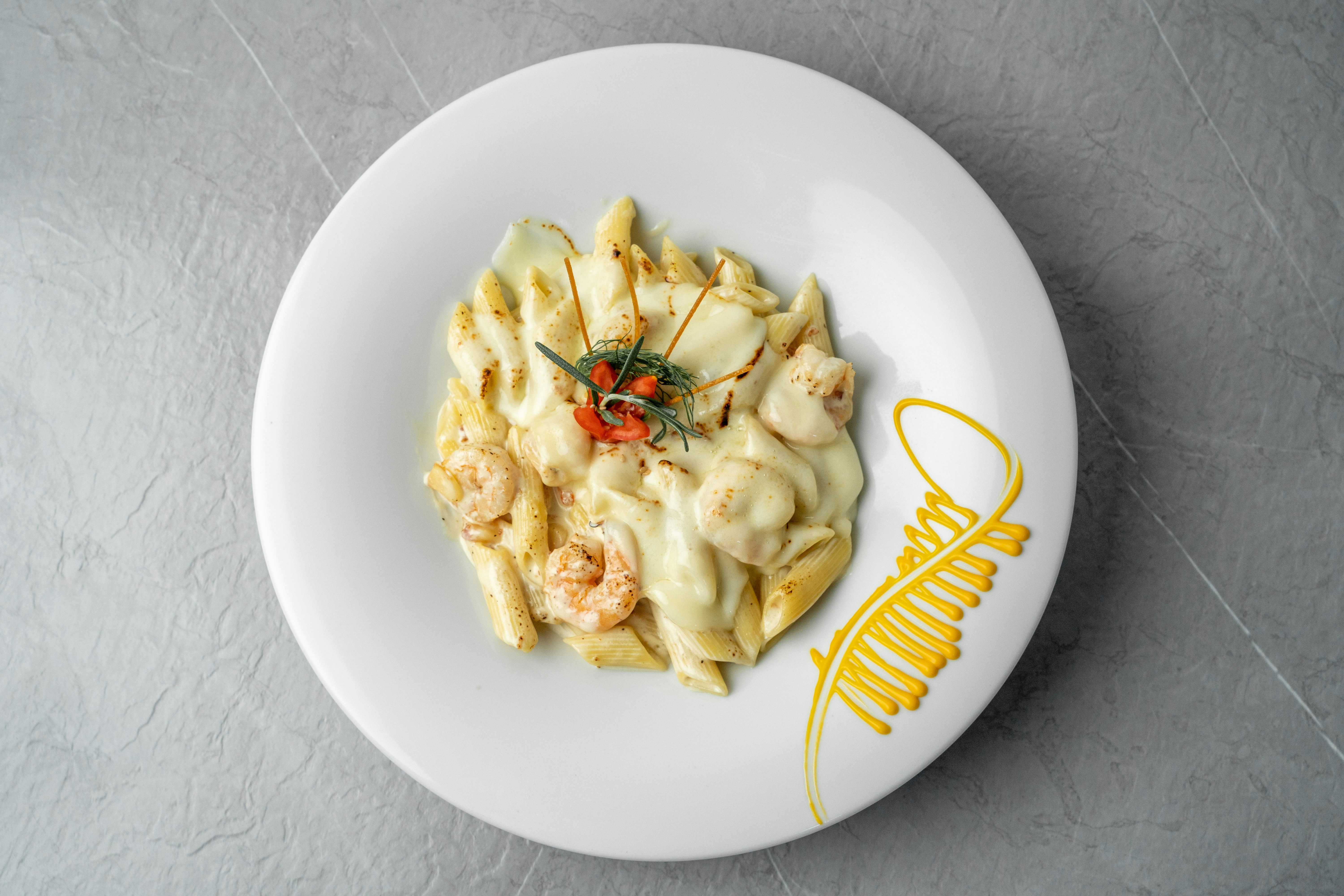 a white plate topped with pasta covered in sauce