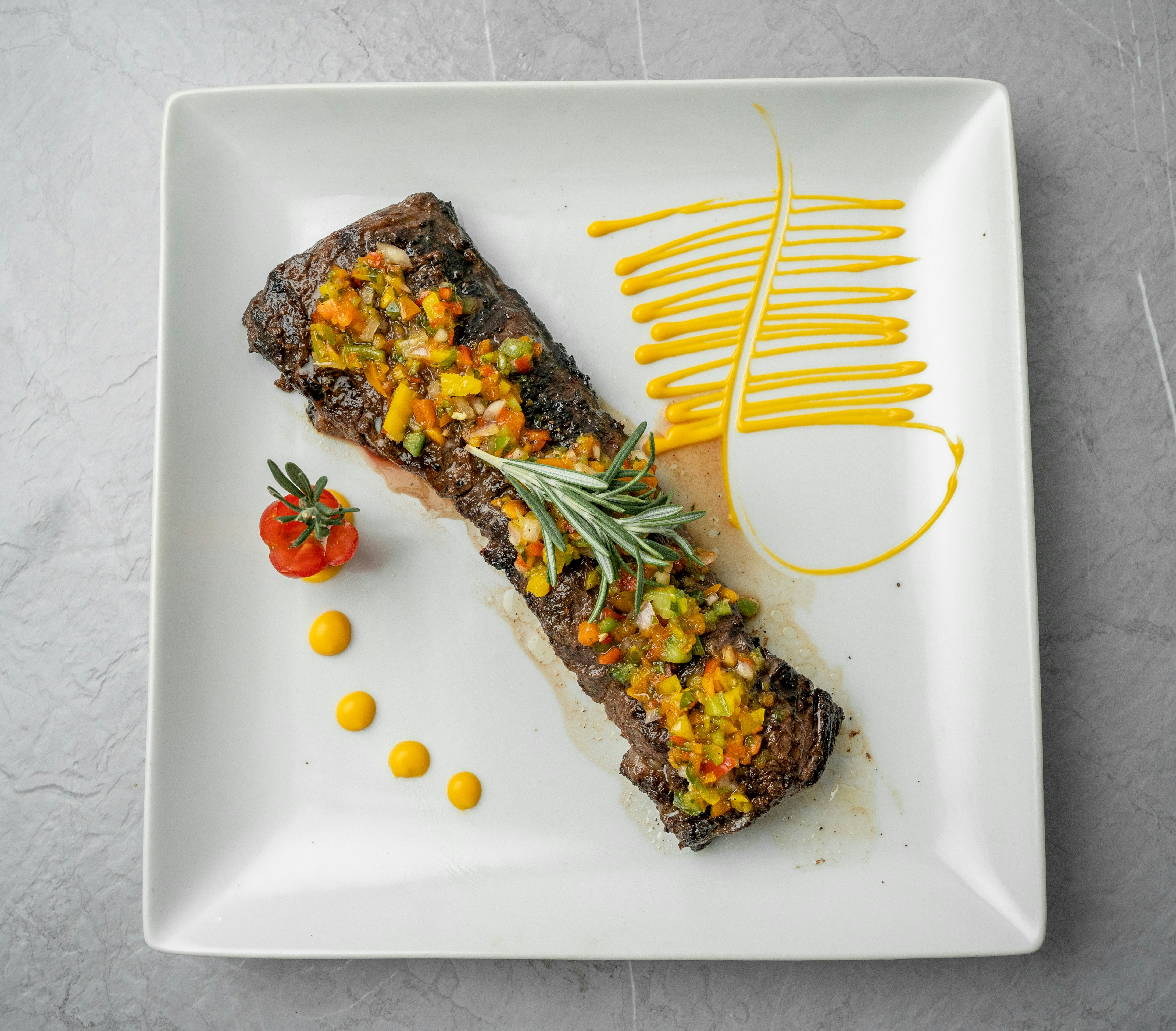 a white plate topped with a piece of meat and vegetables