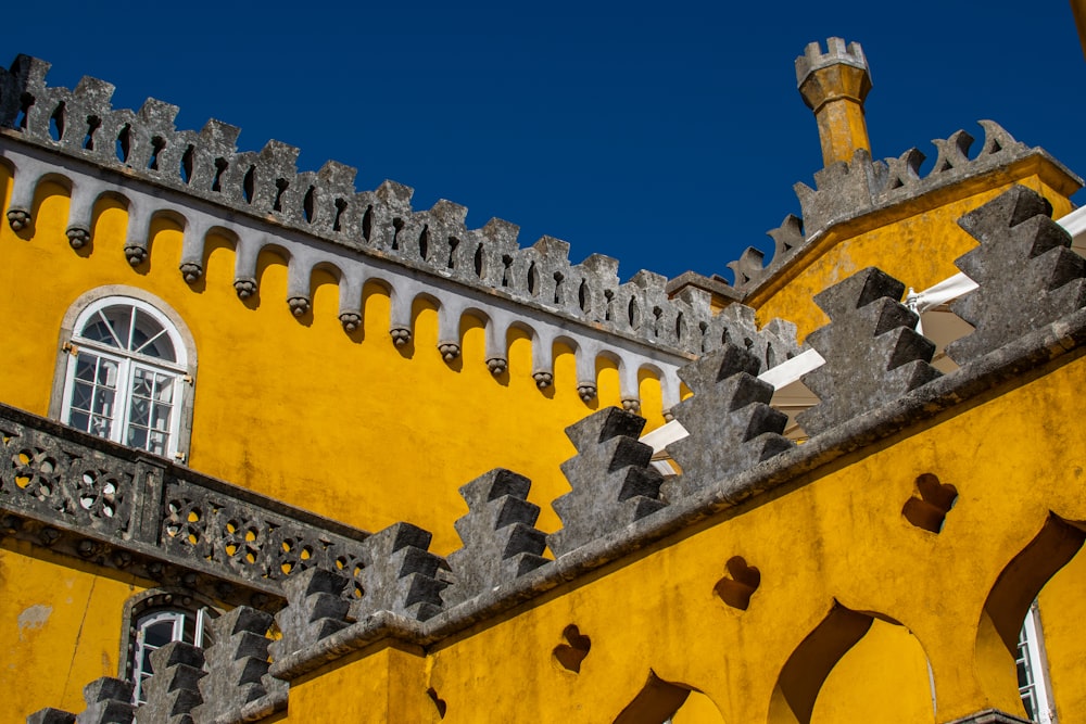 un gran edificio amarillo con un reloj a un lado