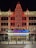 The image features the front facade of a performing arts center named Providence. The building is ornately decorated, with a large vertical neon sign displaying 'PROVIDENCE' twice. The entrance is brightly lit with a marquee sign advertising a '2024 IPMA launch party' scheduled for December 9, 2023. The architecture is detailed and well-lit, especially in the nighttime setting. There are two people standing near the entrance.