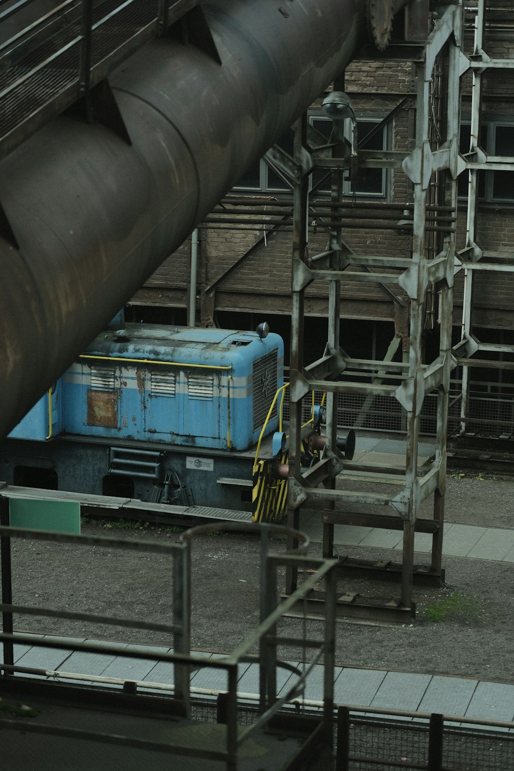 a blue train traveling down train tracks next to a building