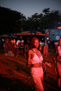 A happy young woman holding concert tickets with a vibrant festival background.