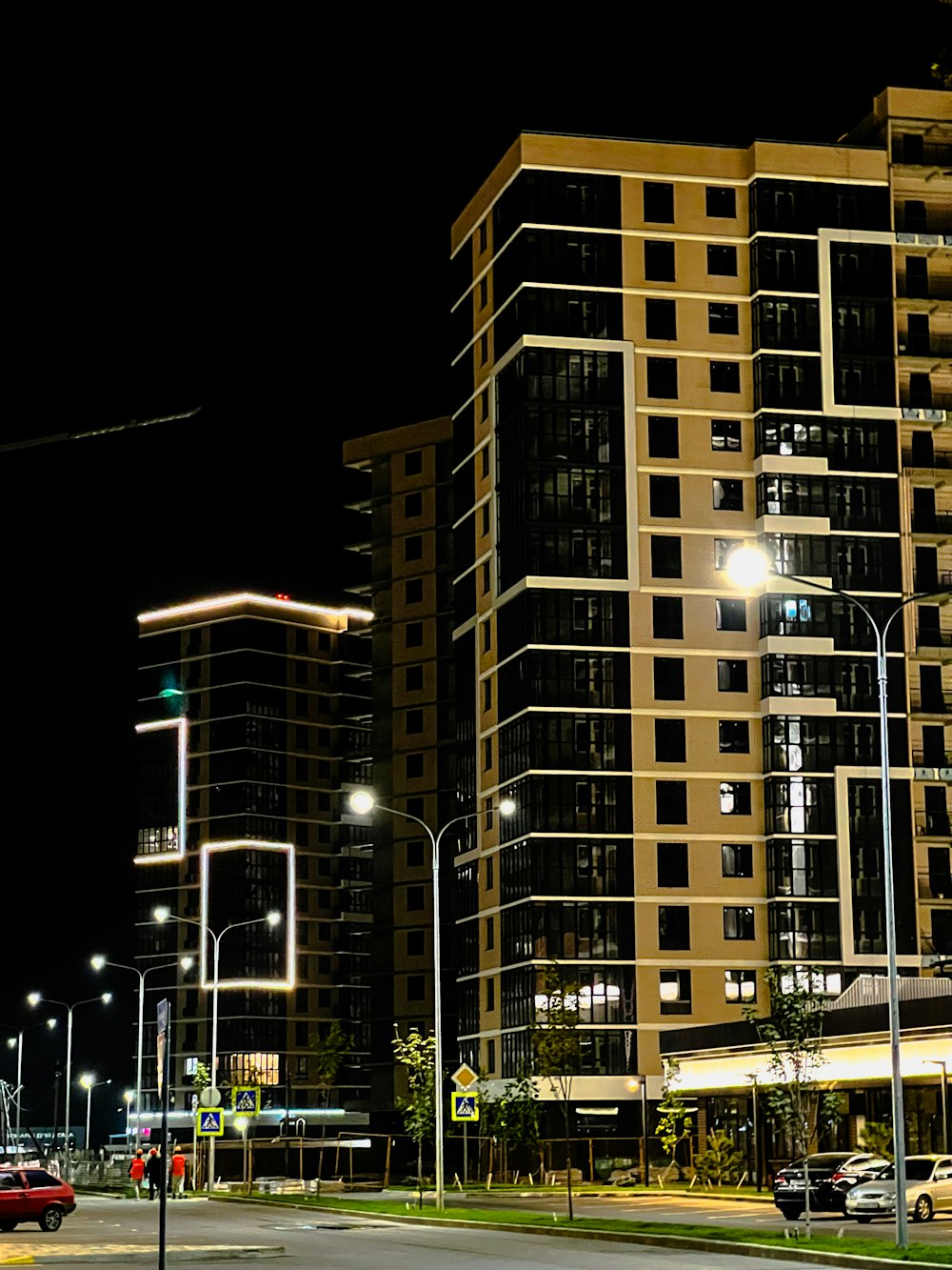 a city street at night with tall buildings