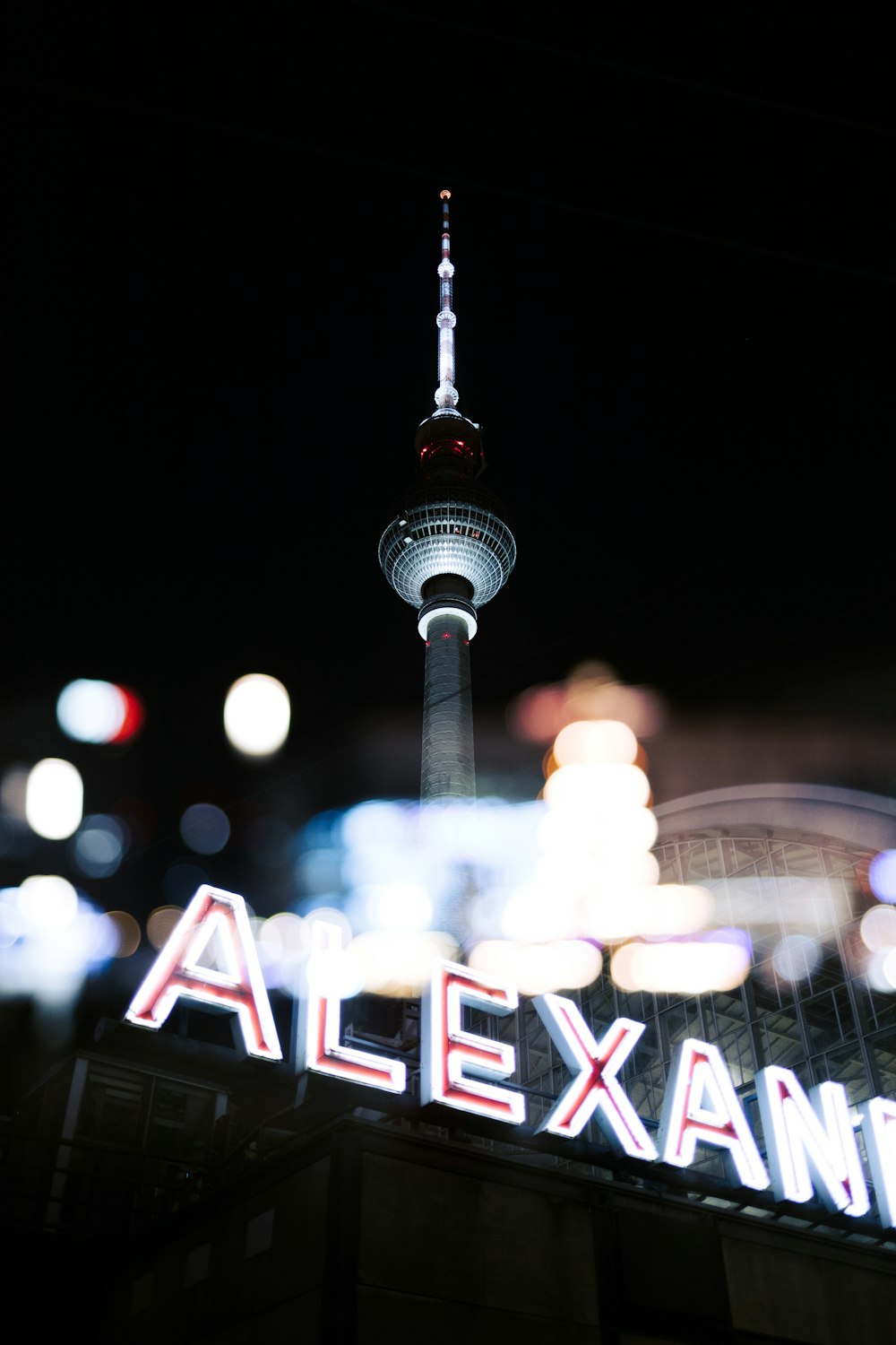 a picture of a city at night with a neon sign