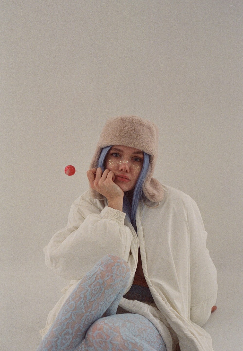 a woman with blue hair sitting on the ground