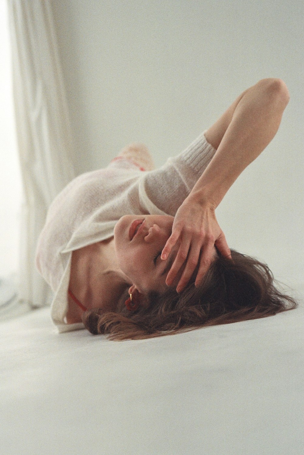 a woman laying on her back on a bed