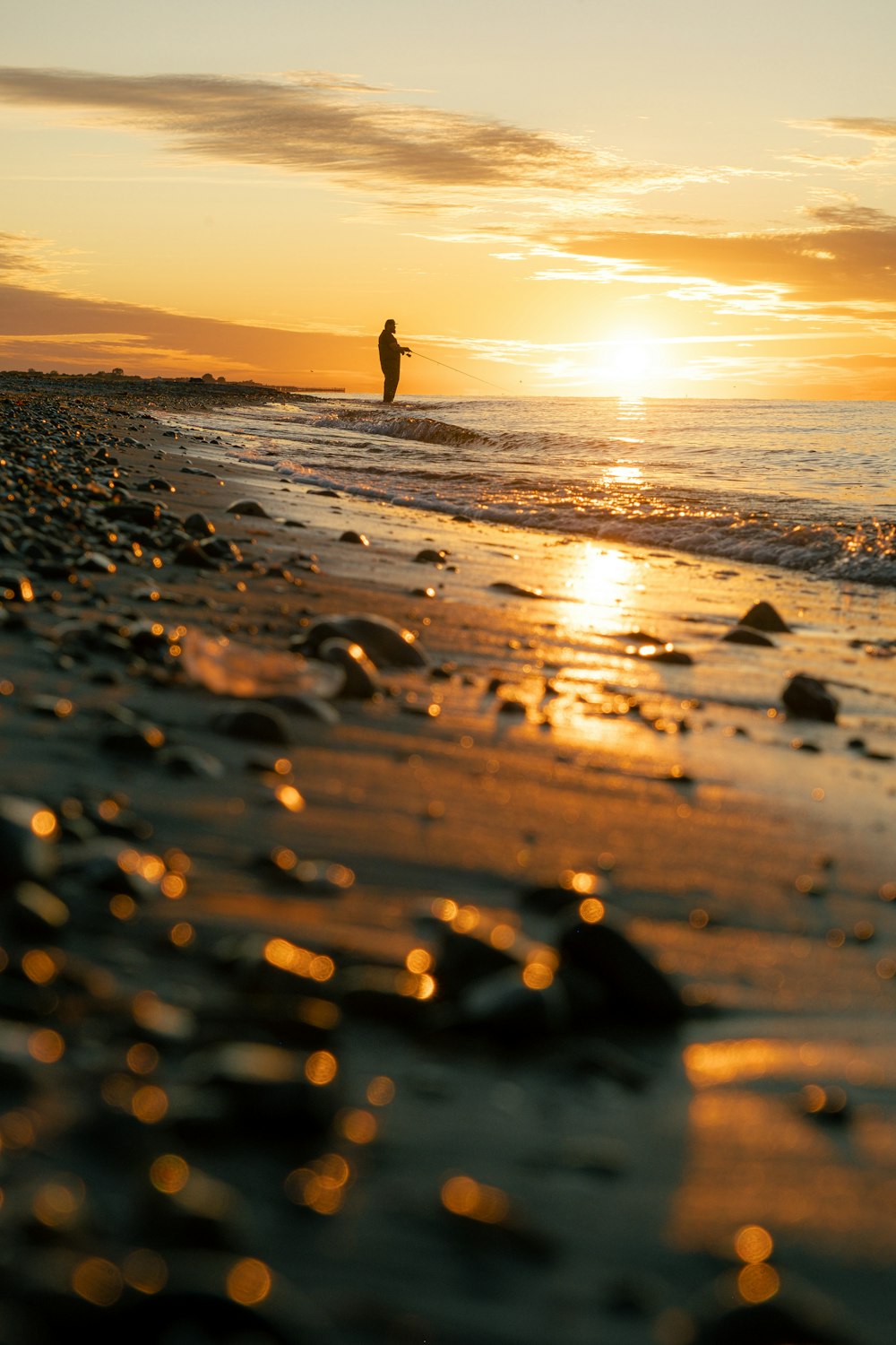 a person standing on a beach next to the ocean