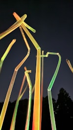 Young students assembling colorful water rockets with neon-lit tools under a modern space-themed tent.