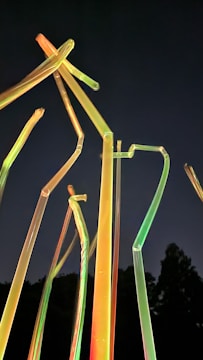 Young students assembling colorful water rockets with neon-lit tools under a modern space-themed tent.