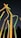 A group of translucent, colorful sticks or tubes is standing upright against a dark night sky. The tubes are illuminated in yellow, orange, and green hues, creating a vibrant glowing effect.