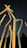 A group of translucent, colorful sticks or tubes is standing upright against a dark night sky. The tubes are illuminated in yellow, orange, and green hues, creating a vibrant glowing effect.