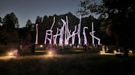 Nighttime photo of a community art installation glowing softly in a public park.
