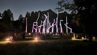 Nighttime photo of a community art installation glowing softly in a public park.
