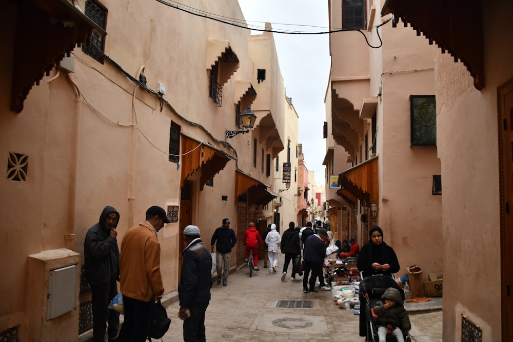 a group of people walking down a street next to tall buildings