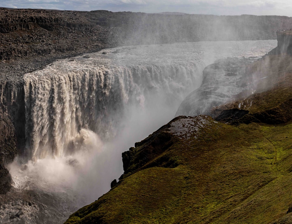 a view of a waterfall from the side of a cliff