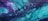 A vibrant abstract painting featuring dynamic swirls and patterns with a fluid, marbled effect. The composition consists of shades of teal and purple blending harmoniously with smooth curves and circular formations, giving a sense of movement and depth.