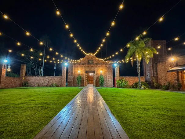 A serene backyard softly lit with warm soffit lighting highlighting the patio area at dusk.