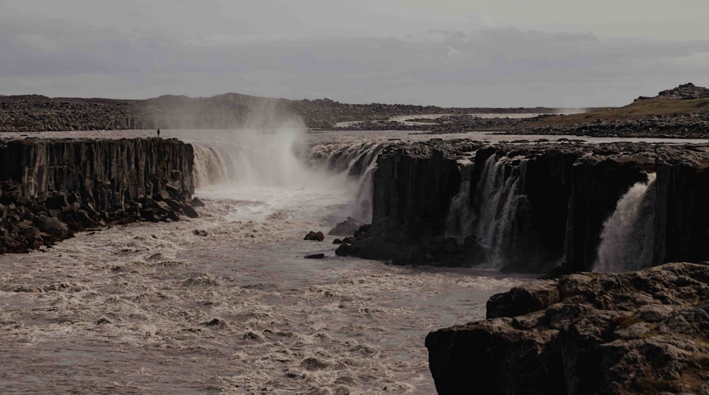 a large waterfall in the middle of a body of water