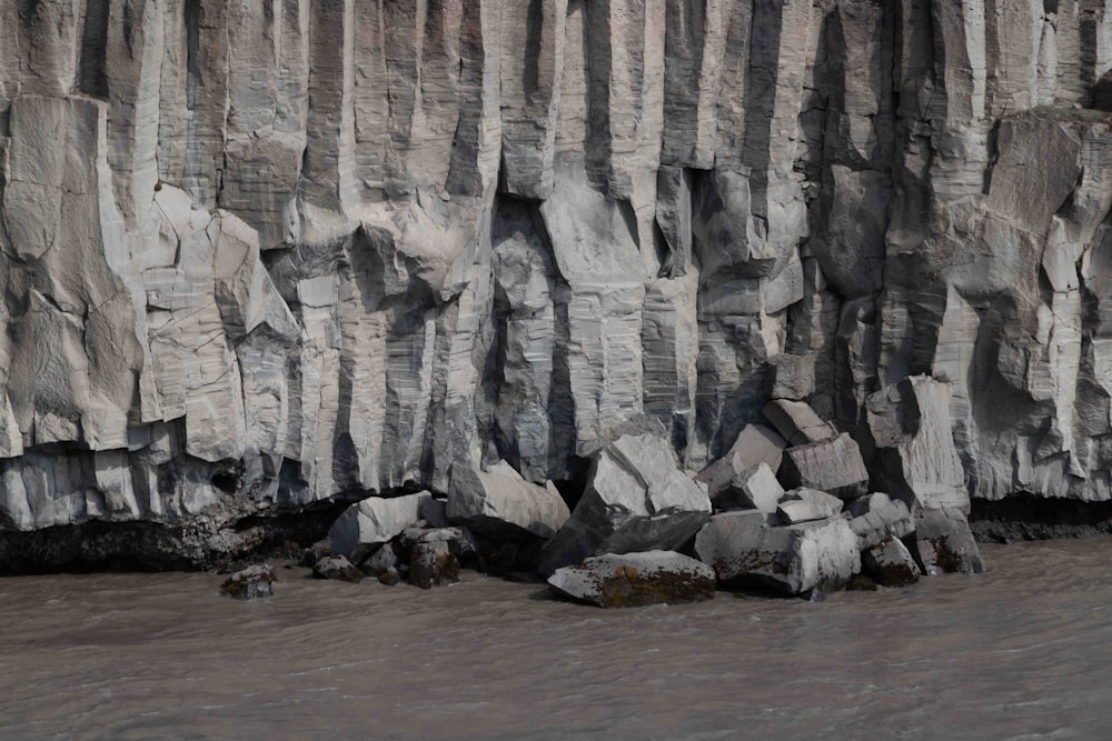 a large rock formation next to a body of water