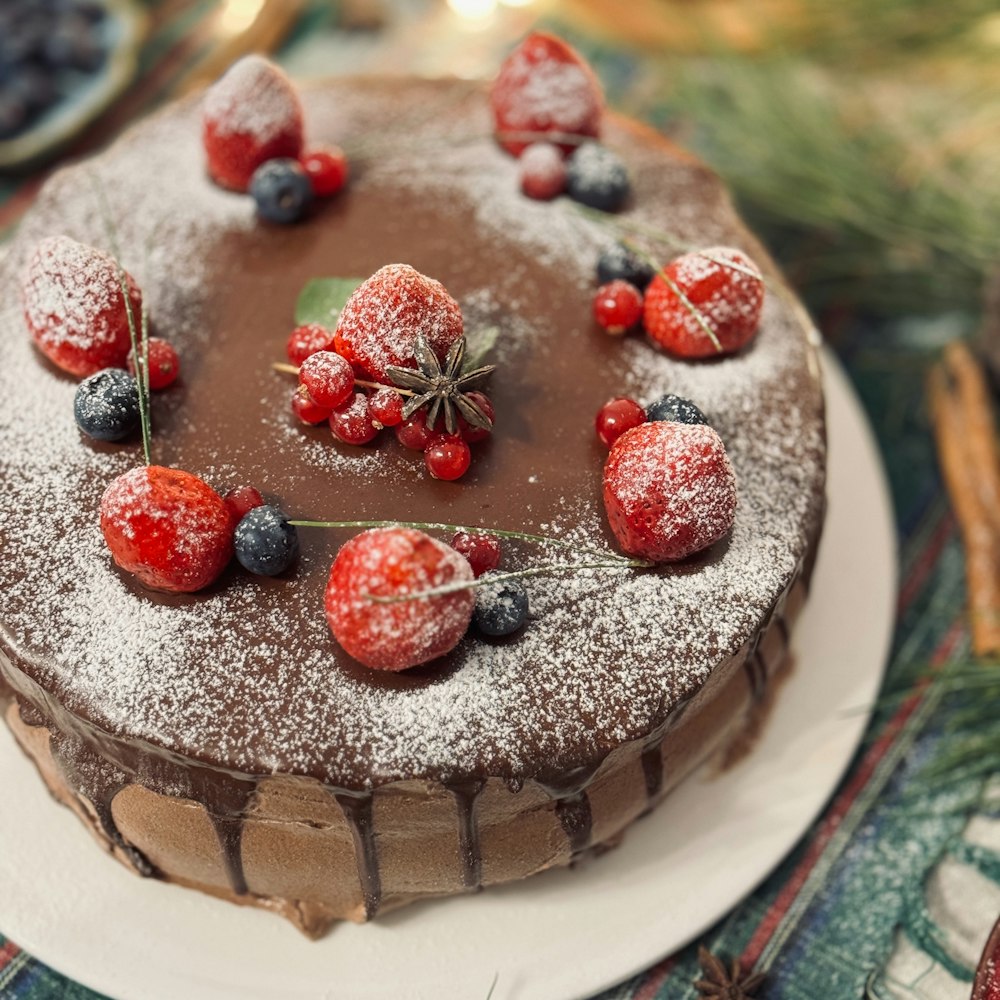 a chocolate cake topped with berries and powdered sugar