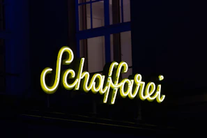 Exterior view of Huefyse in Basel with traditional signage and evening glow
