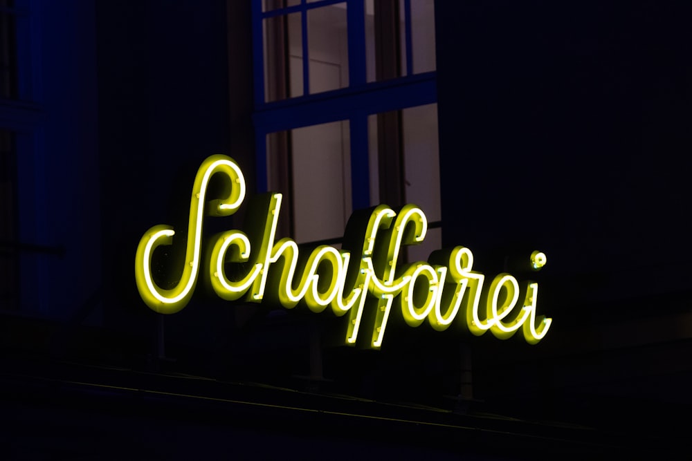 a neon sign is lit up in the dark