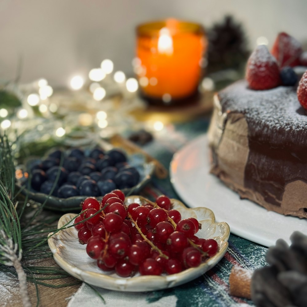 a table topped with a cake covered in frosting and berries